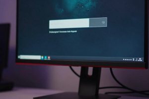 Игровой компьютер с монитором, на котором тёмный экран загрузки